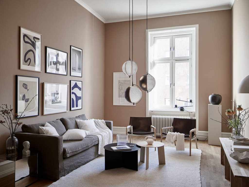 A dusty pink living room with black accents and a grey sofa