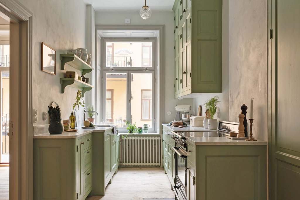 A sage green farmhouse kitchen in a galley layout
