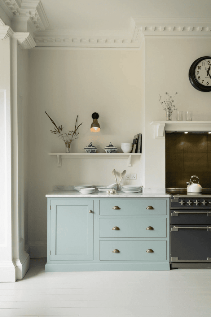 A pale blue kitchen against off-white walls