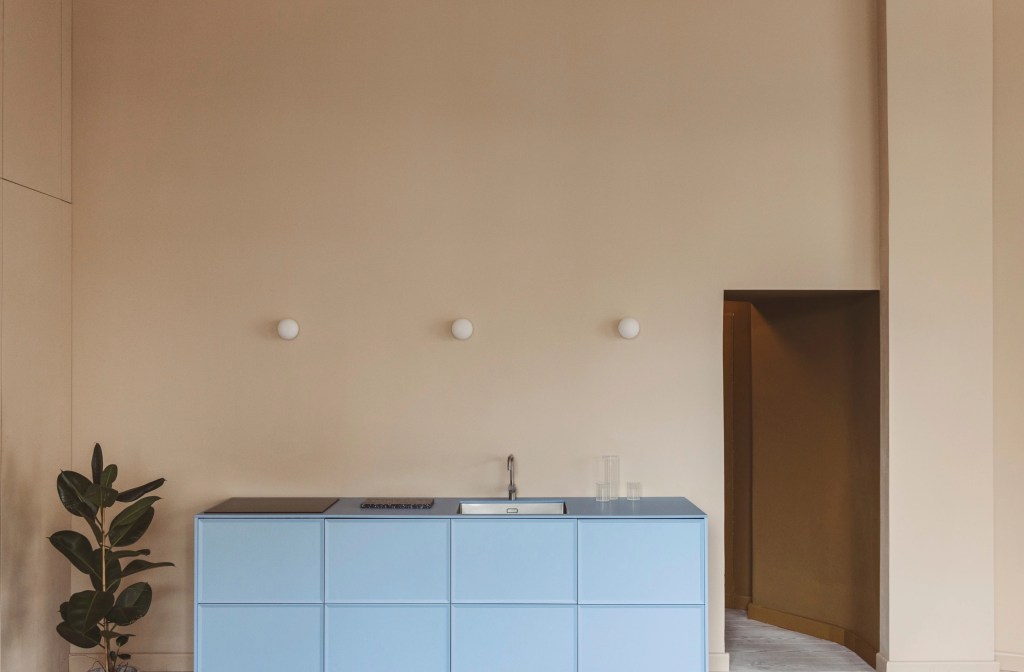 A light blue kitchen against beige walls