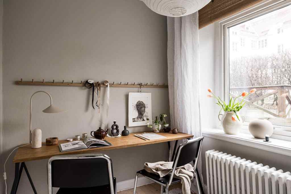A home office space with warm grey walls and a double desk
