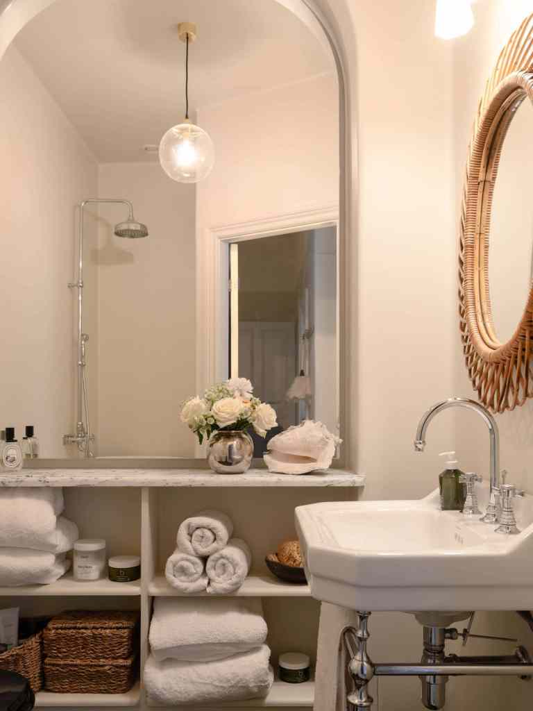 A farmhouse bathroom with a full size mirror that makes the space appear bigger