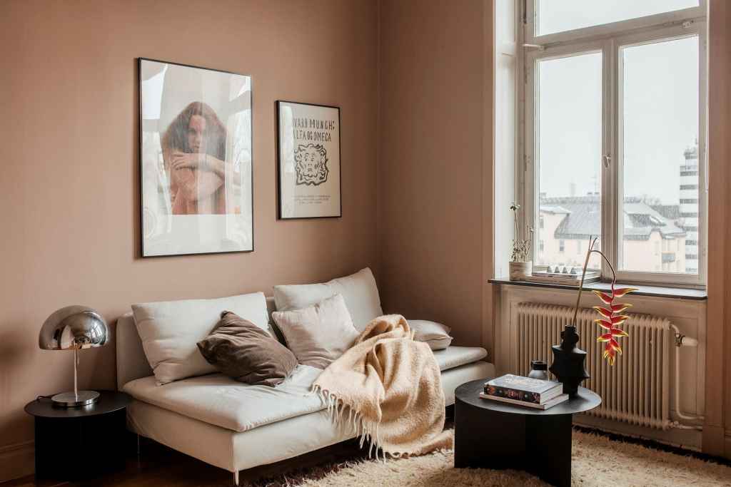 A muted pink living room with a white couch