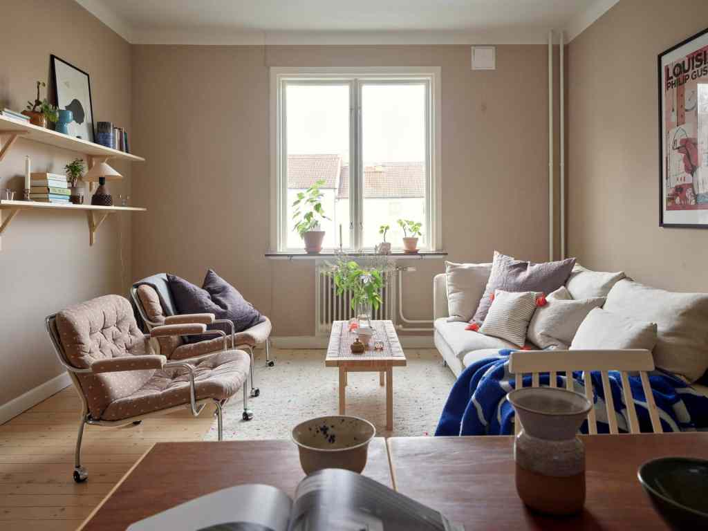 A muted pink living room with a neutral decor and pops of blue