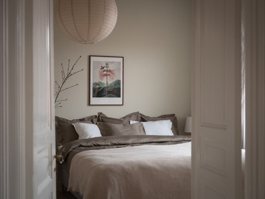 A bedroom with an eggshell wall color and a subtle color palette