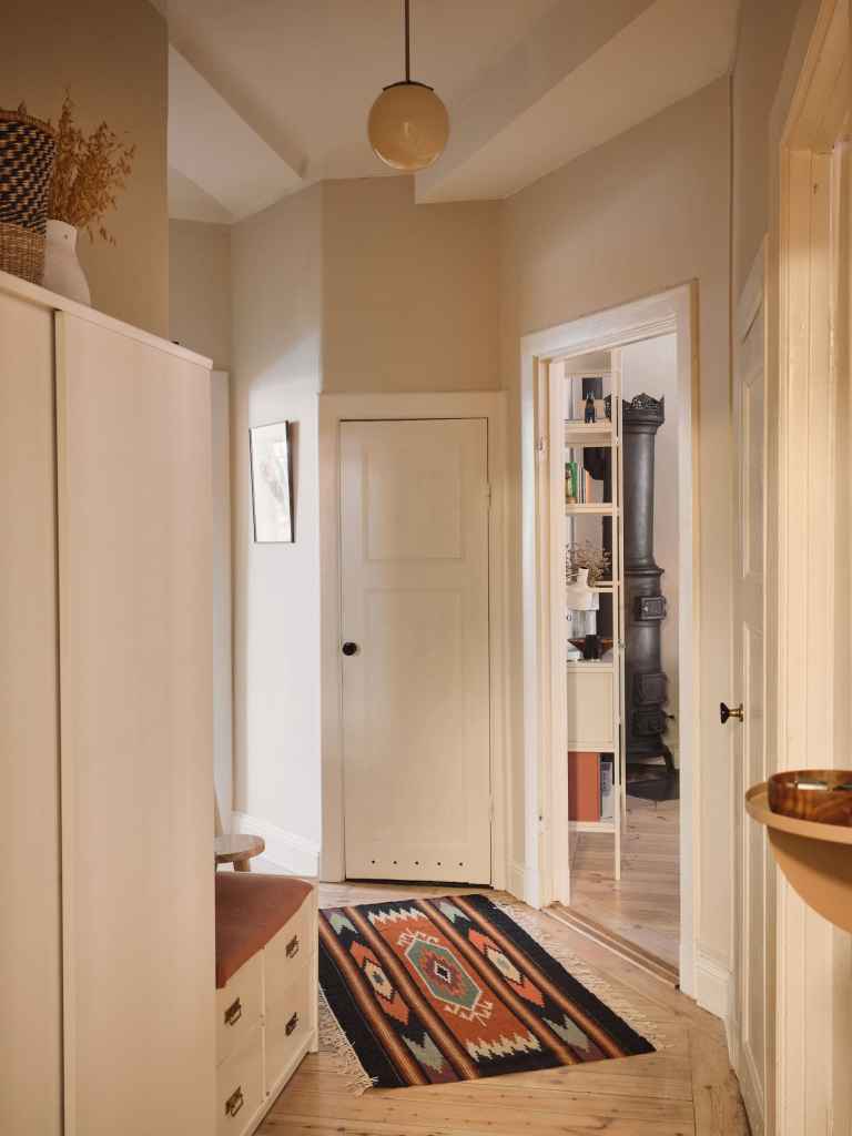 A small hallway with an asymmetrical floor plan and a combination of storage with seating