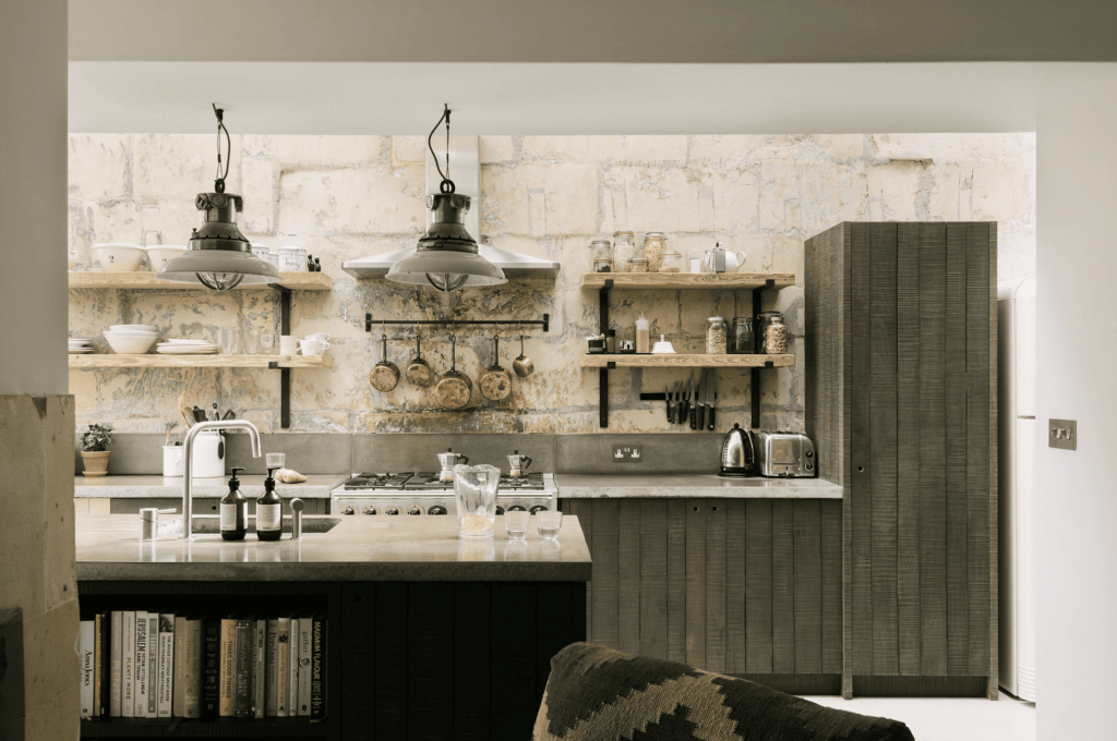 A large brick backsplash in a modern kitchen with dark wood cabinets and a concrete countertop