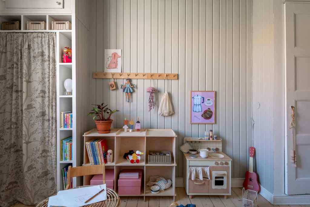 A kids room with light grey wainscoting on the walls