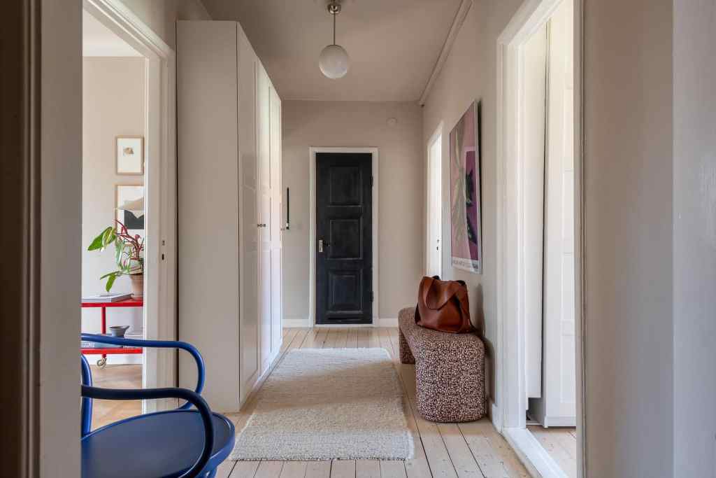 A hallway with a fabric seating bench