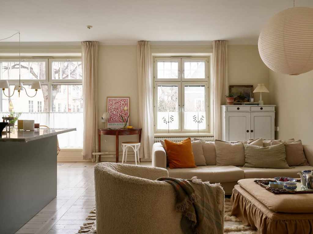 A beige living room with a neutral color palette in the decor, vintage elements