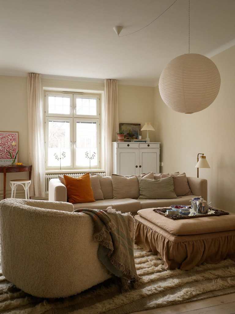 A beige living room with a neutral color palette in the decor, vintage elements