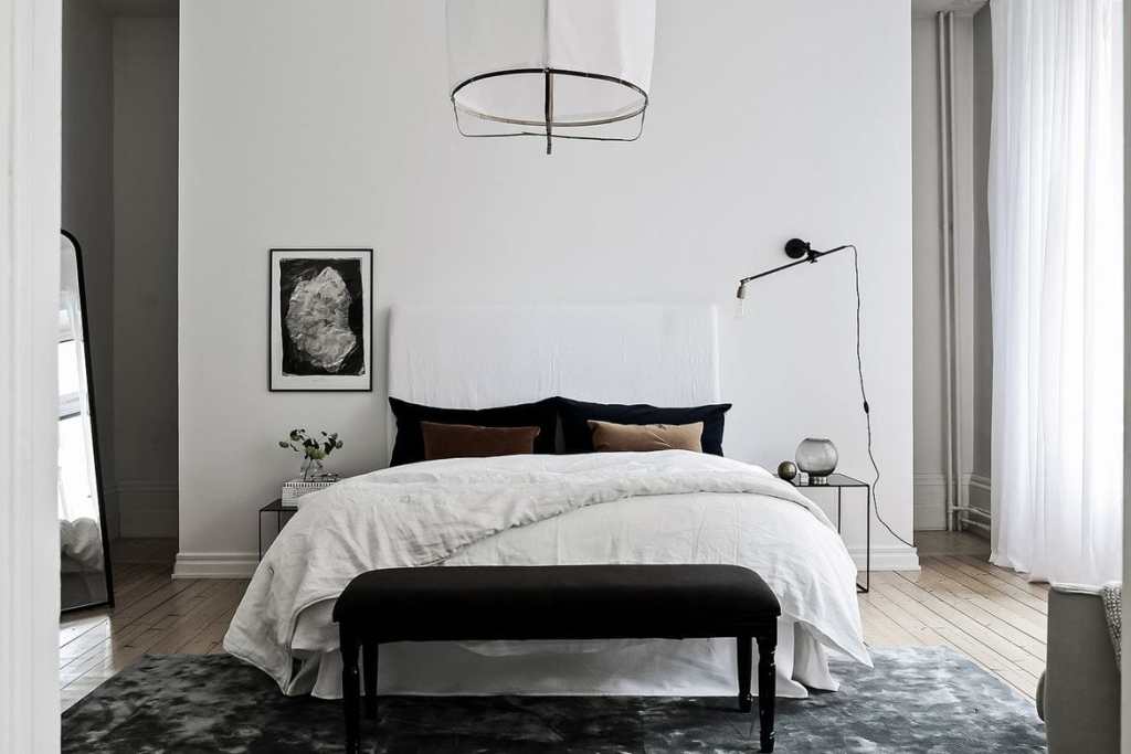 A historic bedroom space with white walls and black accents