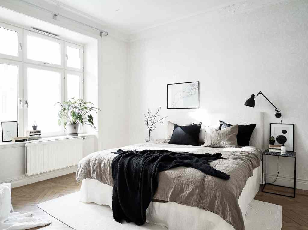 a black and white bedroom design with tan bedding