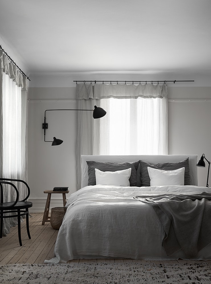 A cozy bedroom design with a black, white and grey palette