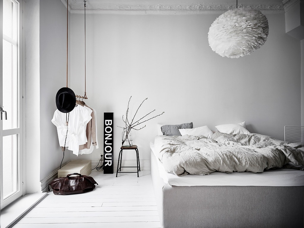 A black and white bedroom design with grey tones in the bedding