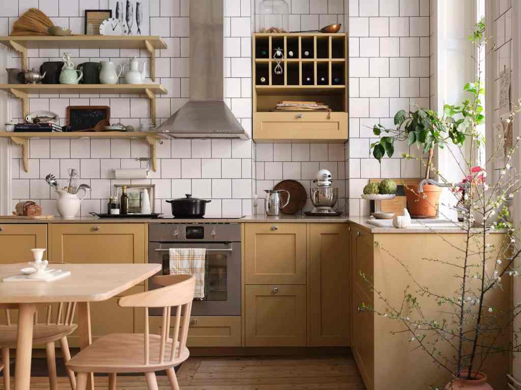 A yellow kitchen with white tiles and black grout in an L-shaped layout