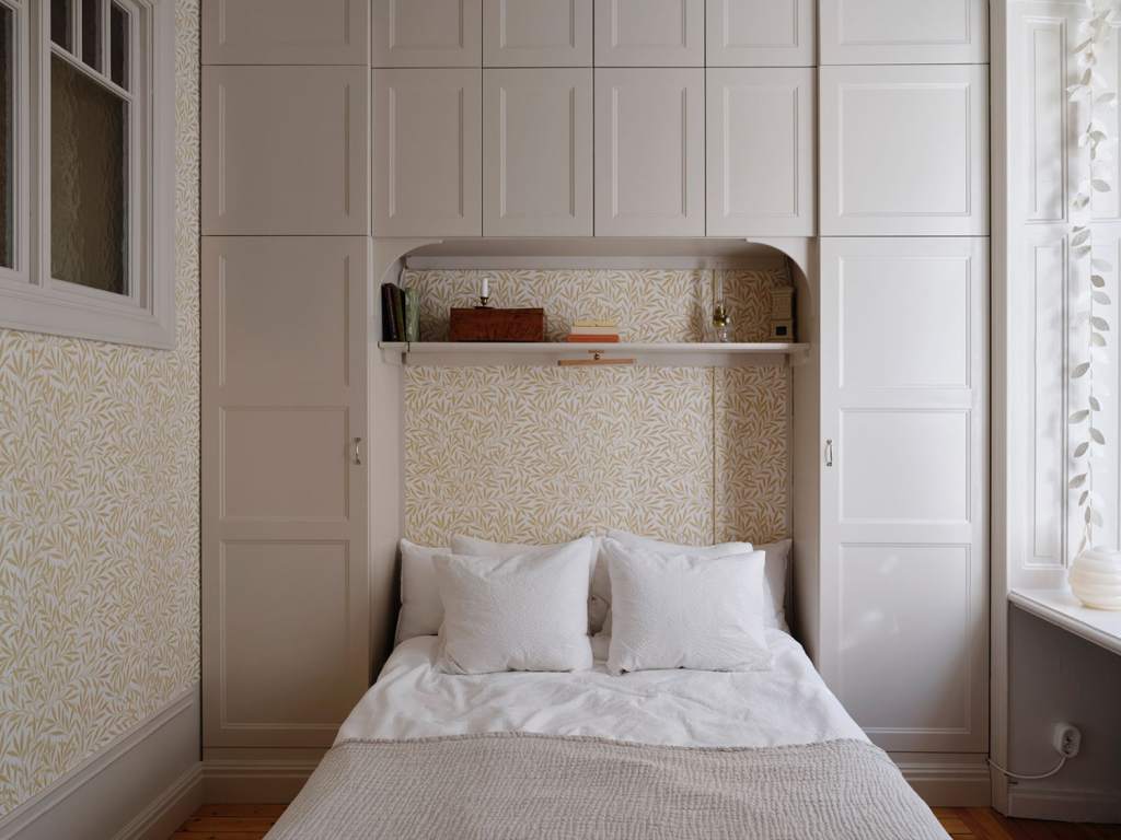 A small bedroom with a wardrobe built around the bed